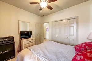 Bedroom featuring ceiling fan, light carpet, and a closet