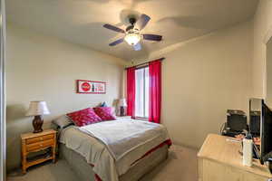 Carpeted bedroom with ceiling fan