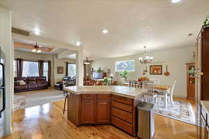 Kitchen featuring light hardwood / wood-style flooring, a kitchen island, hanging light fixtures, and plenty of natural light