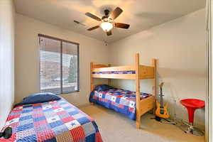 Bedroom with ceiling fan and light carpet