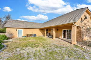 Rear view of property featuring a lawn, a patio, and central AC unit