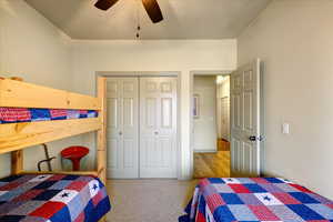 Carpeted bedroom featuring a closet and ceiling fan