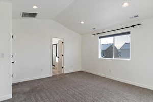 Unfurnished room with carpet flooring and lofted ceiling