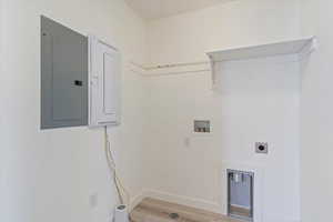 Washroom with washer hookup, electric dryer hookup, light hardwood / wood-style floors, and electric panel