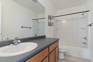 Full bathroom featuring bathtub / shower combination, wood-type flooring, vanity, and toilet