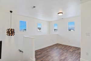 Spare room featuring a textured ceiling and dark hardwood / wood-style flooring