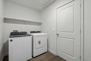 Laundry room with washer and dryer and dark hardwood / wood-style flooring