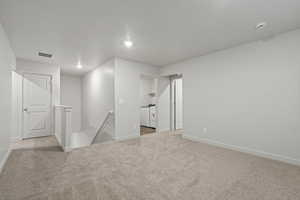 Carpeted empty room featuring a textured ceiling and independent washer and dryer