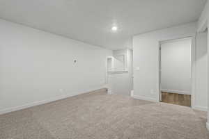 Unfurnished bedroom featuring carpet, a textured ceiling, and a closet