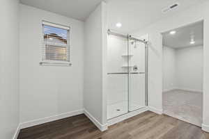 Bathroom with walk in shower and hardwood / wood-style floors