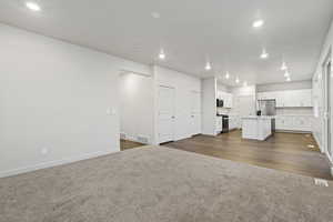 Unfurnished living room featuring dark colored carpet