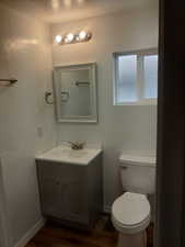 Bathroom featuring hardwood / wood-style floors, vanity, toilet, and a textured ceiling