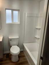 Bathroom with hardwood / wood-style flooring, vanity, and toilet