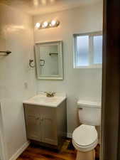 Bathroom featuring vanity, toilet, wood-type flooring, and a textured ceiling