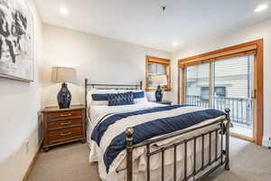 Bedroom featuring light carpet and access to outside