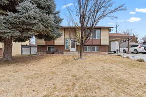 View of front of home featuring a front lawn and a carport