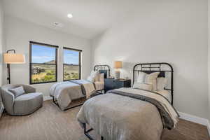 Bedroom with lofted ceiling and light carpet