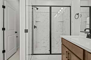 Bathroom featuring vanity and an enclosed shower