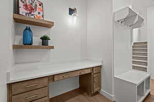 Mudroom with built in desk and light hardwood / wood-style floors