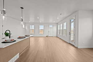 Kitchen featuring light hardwood / wood-style floors and hanging light fixtures