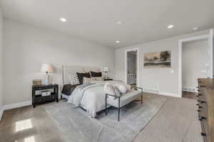 Bedroom with ensuite bathroom and light hardwood / wood-style floors