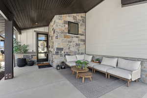 View of exterior entry with an outdoor living space and a patio