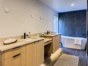 Bathroom featuring tile patterned floors, a bathing tub, and vanity