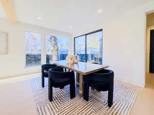 Dining area with light hardwood / wood-style flooring and beamed ceiling