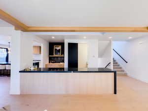 Kitchen with kitchen peninsula, light brown cabinetry, and tasteful backsplash