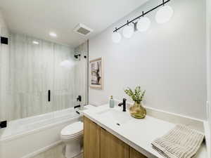 Full bathroom featuring tiled shower / bath combo, toilet, and vanity