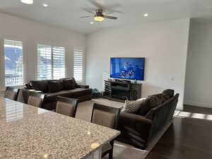 Living room featuring ceiling fan, hardwood / wood-style floors, and lofted ceiling