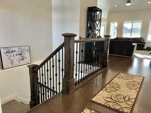 Stairs with hardwood / wood-style flooring and ceiling fan