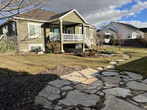 Back of house featuring a porch, central AC unit, and a lawn