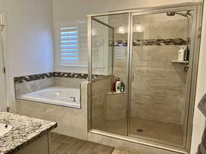 Bathroom featuring vanity and shower with separate bathtub