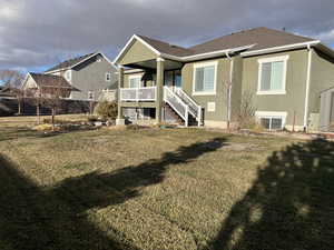 Back of house with a lawn and central AC unit