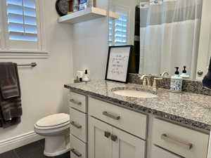 Bathroom featuring tile patterned flooring, vanity, and toilet