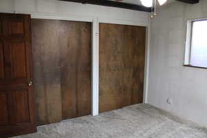 Unfurnished bedroom featuring light carpet, ceiling fan, and two closets