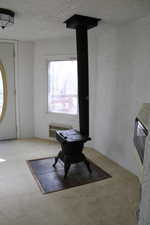 Interior space featuring carpet flooring, a textured ceiling, and heating unit