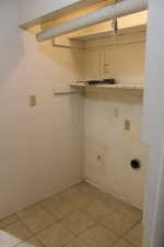 Clothes washing area featuring electric dryer hookup and light tile patterned flooring