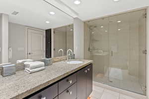 Bathroom with vanity, tile patterned floors, and a shower with door