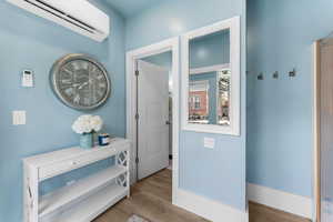 Hallway featuring light hardwood / wood-style flooring and a wall mounted AC