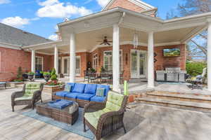 View of patio / terrace with area for grilling, ceiling fan, and an outdoor living space