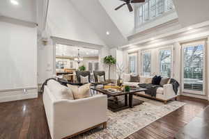 Living room featuring high vaulted ceiling, french doors, ceiling fan with notable chandelier, dark hardwood / wood-style floors, and ornamental molding