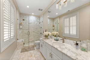 Bathroom featuring a shower with door, a wealth of natural light, and crown molding