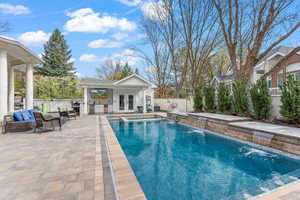 View of swimming pool featuring french doors, an outdoor structure, an outdoor living space, pool water feature, and a patio