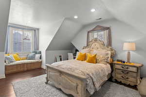 Bedroom with dark hardwood / wood-style flooring and vaulted ceiling