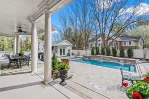 View of swimming pool with an outbuilding, pool water feature, ceiling fan, and a patio area