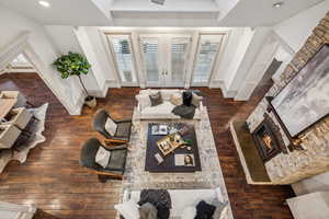 Living room featuring a stone fireplace and dark wood-type flooring