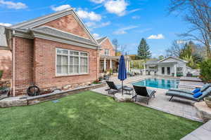 View of swimming pool featuring a lawn, a patio area, and an outbuilding