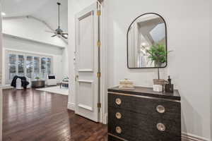 Hallway featuring dark hardwood / wood-style flooring and vaulted ceiling